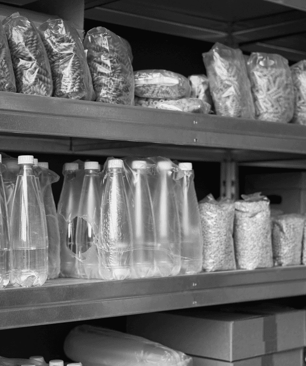 Estantería de almacén con botellas de agua y productos de alimentación envasados